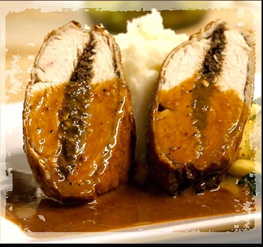 Sliced stuffed meat roll in sauce with mashed potatoes